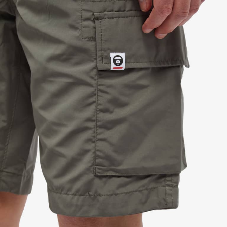 Olive AAPE by Bathing Ape badge cargo shorts with multiple pockets and BAPE logo details on the front and sides.