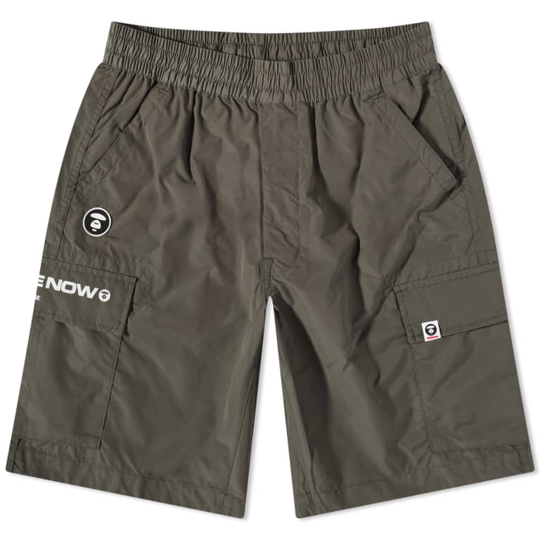 Olive AAPE by Bathing Ape cargo shorts with badge details and multiple pockets, casual streetwear style.