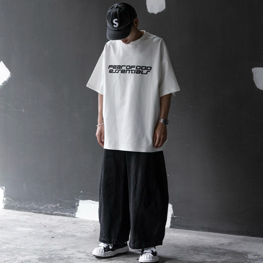 Fear of God Essentials reflective logo ivory ponte 90s tee, casual apparel with upgraded fabric, showcasing the front view.