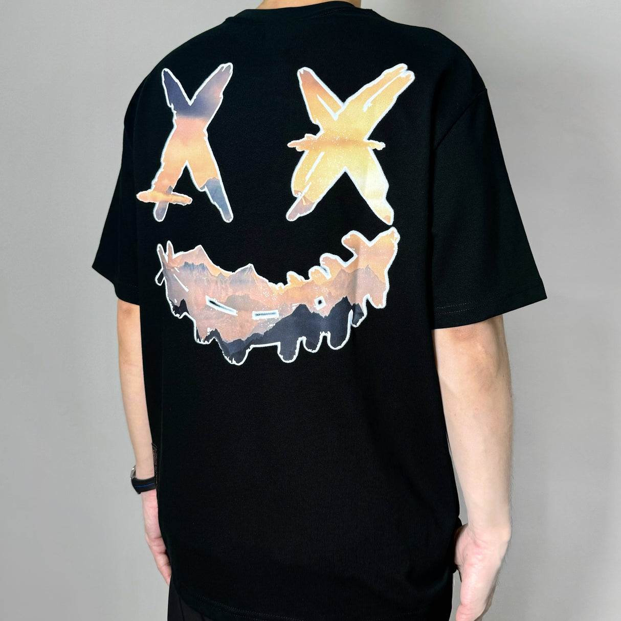 Black Rickyisclown Mountain Smiley Tee featuring a colorful graphic design on the front, casual apparel by RICKYISCLOWN.