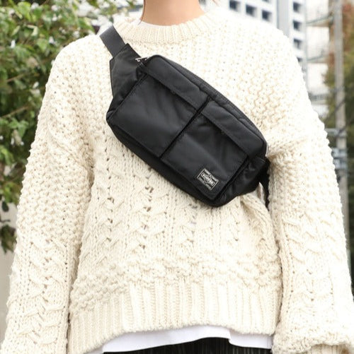 Black Porter Yoshida Japan Tanker Waist Bag with adjustable strap and multiple compartments, made of durable fabric.