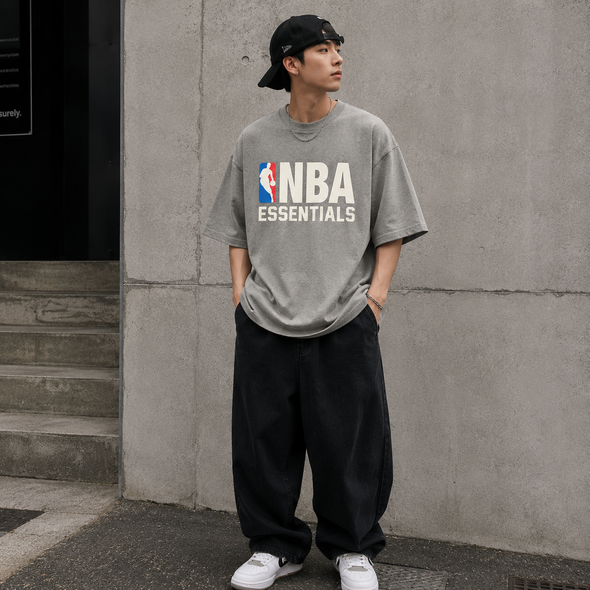 Fear of God Essentials NBA 90s Heavyweight Tee in concrete heather, featuring a relaxed fit and graphic design on the front.