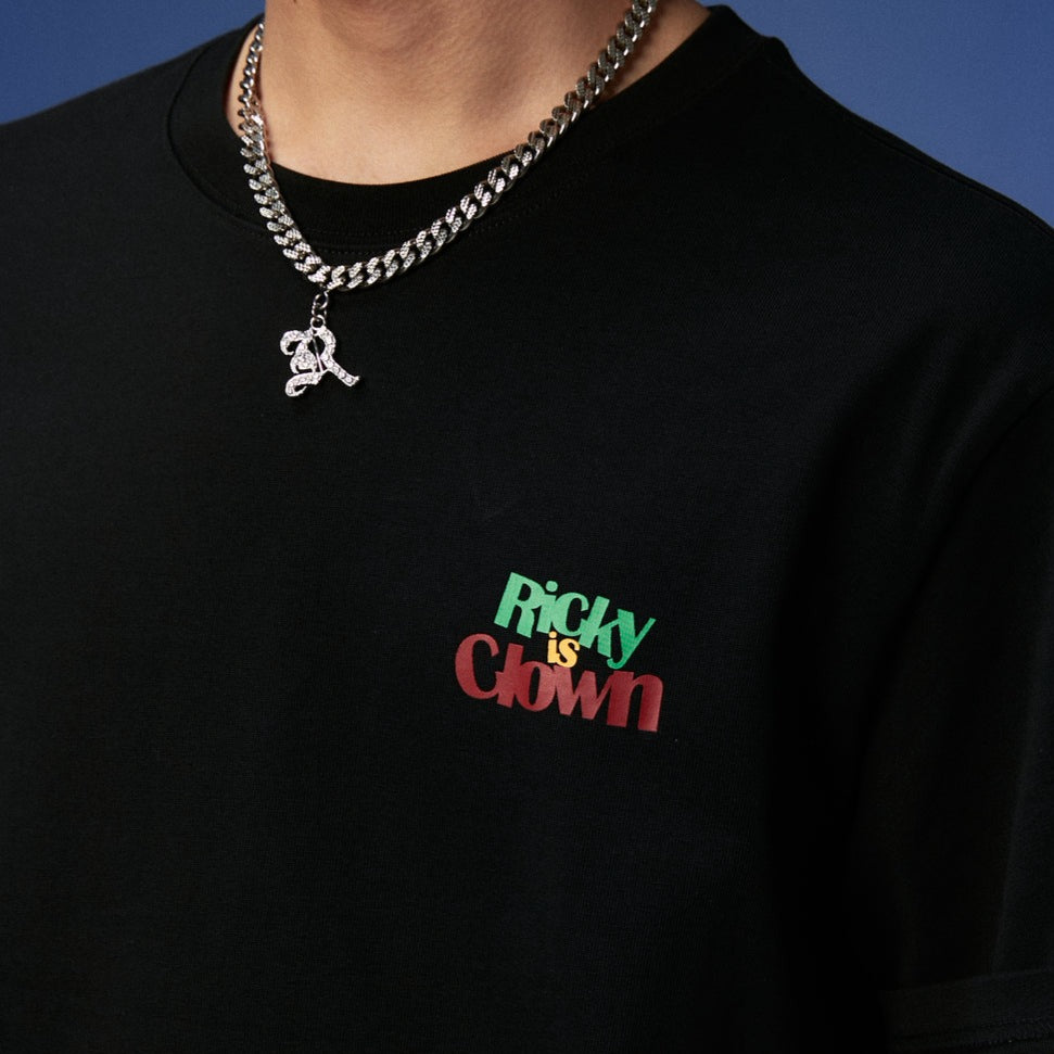 RICKYISCLOWN Joker Laser Reflective Smiley Tee in black, featuring a bright reflective joker smiley graphic on front.