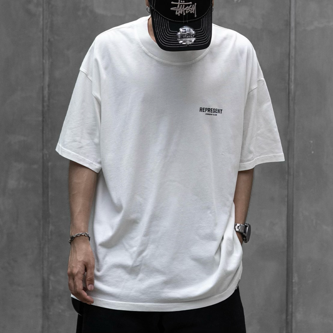 White REPRESENT Owners Club Logo Tee shirt with black graphic print on front, casual streetwear style.