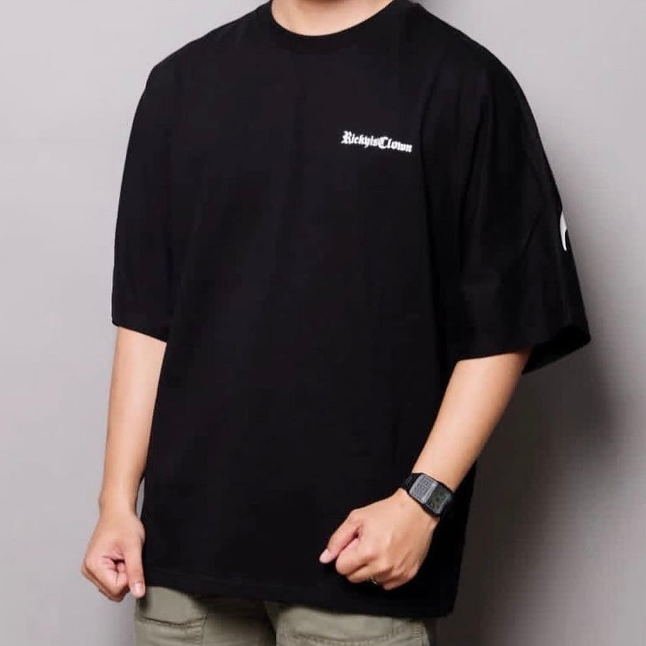Black RICKYISCLOWN Gothic Logo Drop Shoulder T-shirt with graphic design on the front, casual fit, short sleeves.