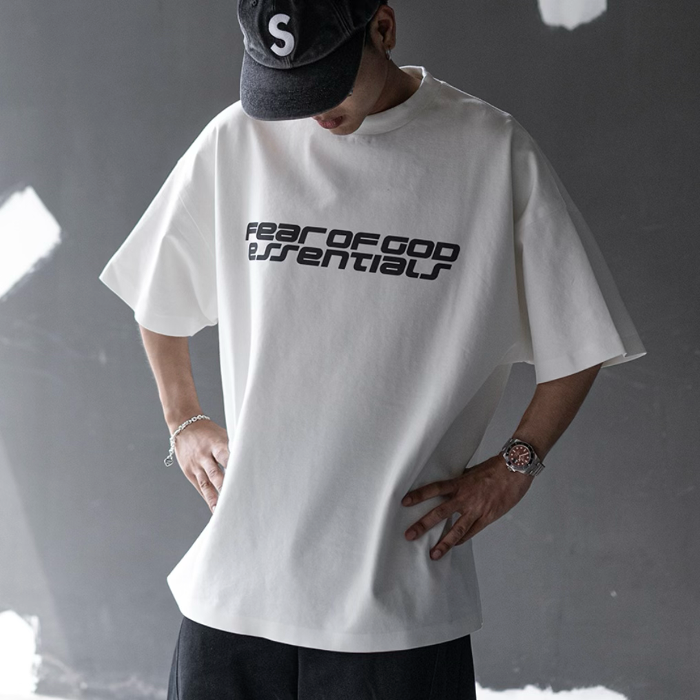 Fear of God Essentials ivory reflective logo ponte 90s tee, upgraded fabric, casual apparel with distinctive logo design.