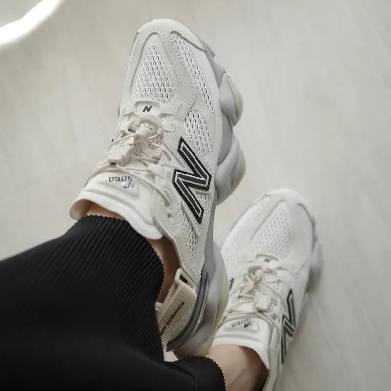 New Balance 9060 Mule sneakers in off-white and mauve with a modern design and comfortable fit.