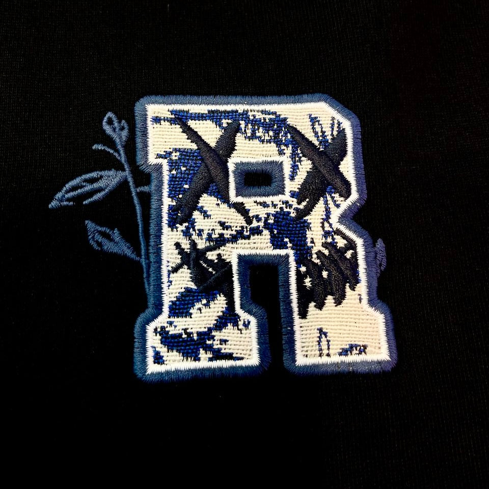 Black Rickyisclown motif embossed tee shirt, casual apparel with clown design, from Rickyisclown brand, front view.