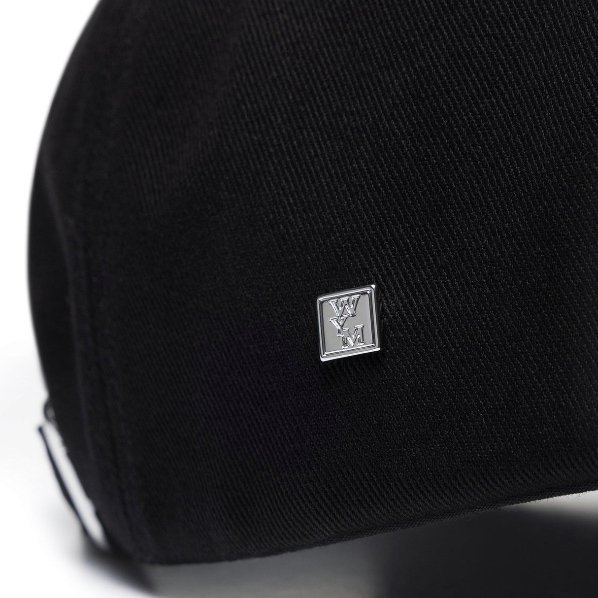 Black Wooyoungmi WYM logo cap, stylish headwear with adjustable strap and embroidered branding, casual accessory for everyday wear.