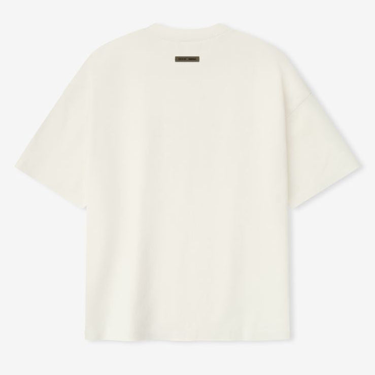 Fear of God Essentials ivory reflective logo ponte 90s tee, upgraded fabric, casual short-sleeve apparel with modern style.