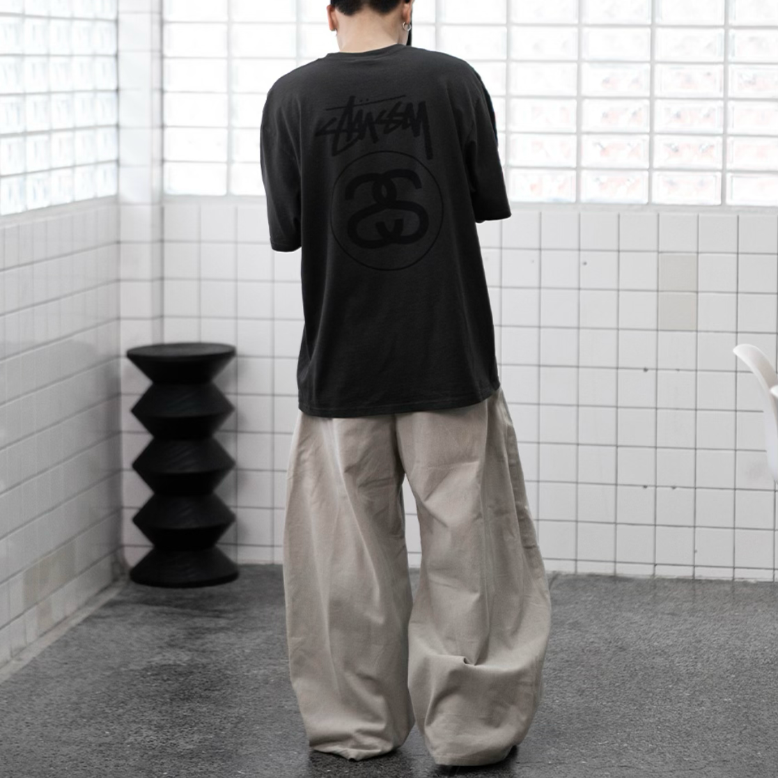 Stussy Stock Logo Tee in faded black, casual apparel with Stussy branding and logo print on front.