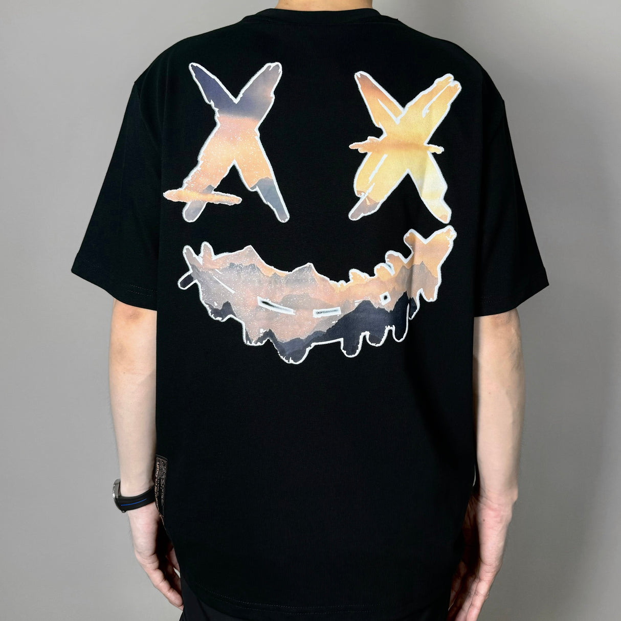 Black Rickyisclown Mountain Smiley Tee featuring a colorful mountain and smiley design on cotton fabric.