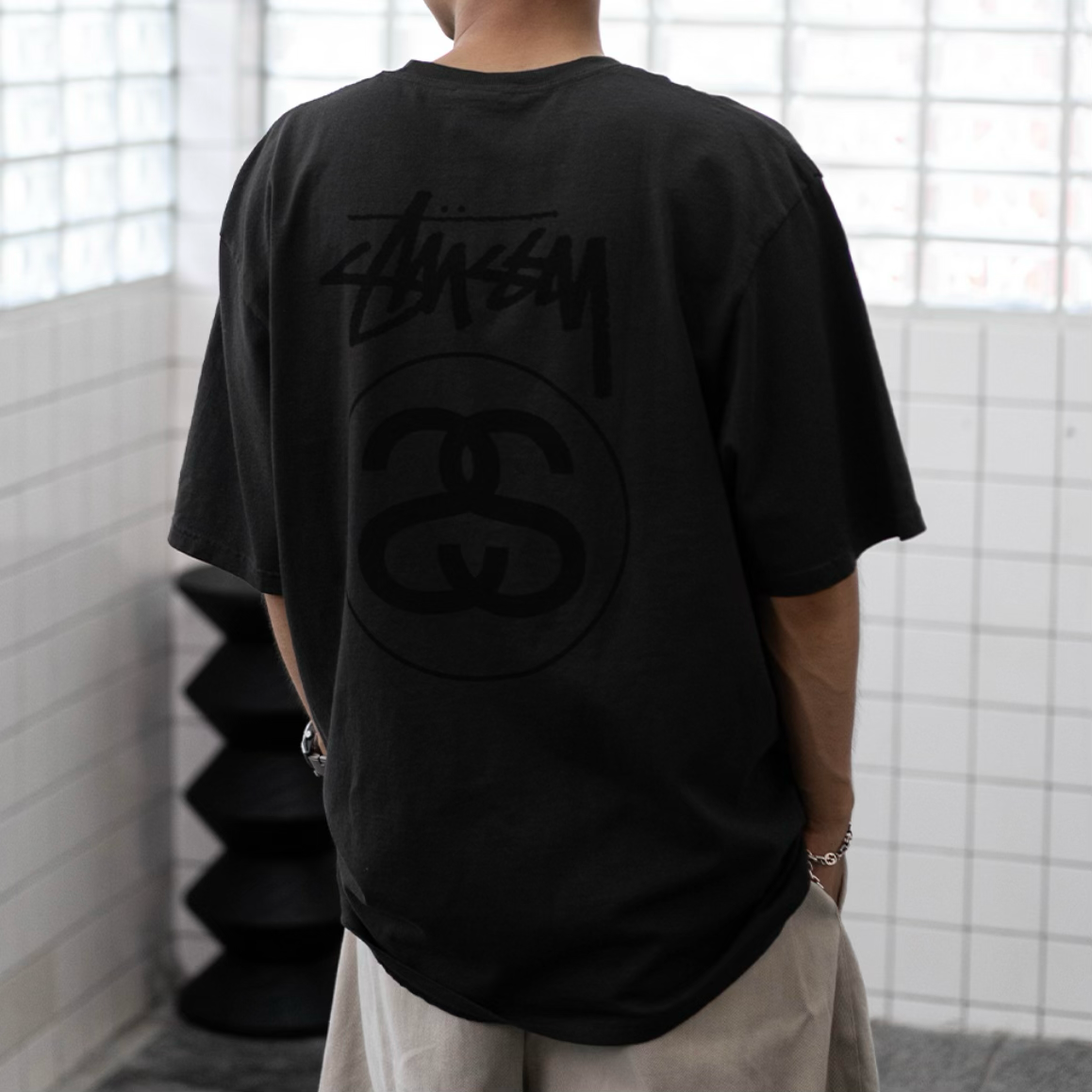 Stussy Stock Logo Tee in faded black, casual apparel featuring the iconic Stussy logo on the front.