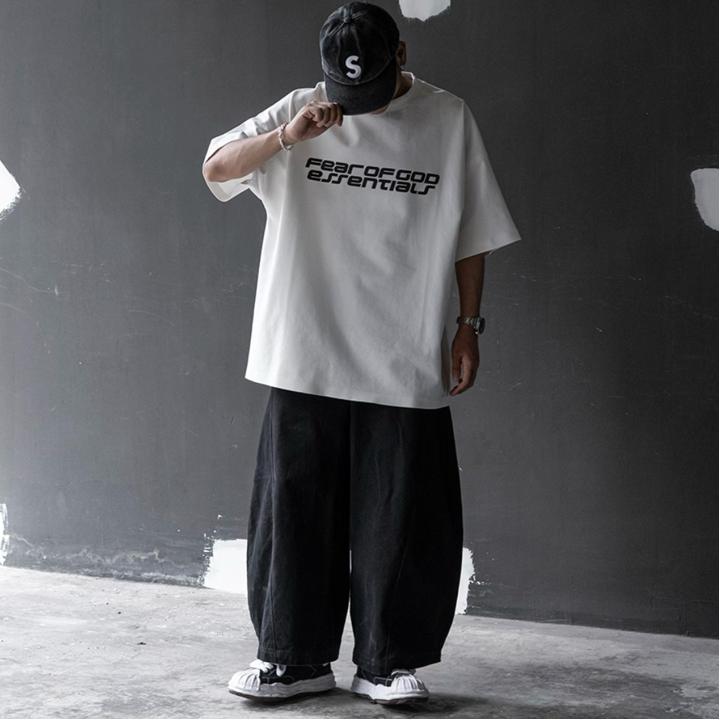 Fear of God Essentials reflective logo ponte 90s tee in ivory, showcasing upgraded fabric and classic fit.