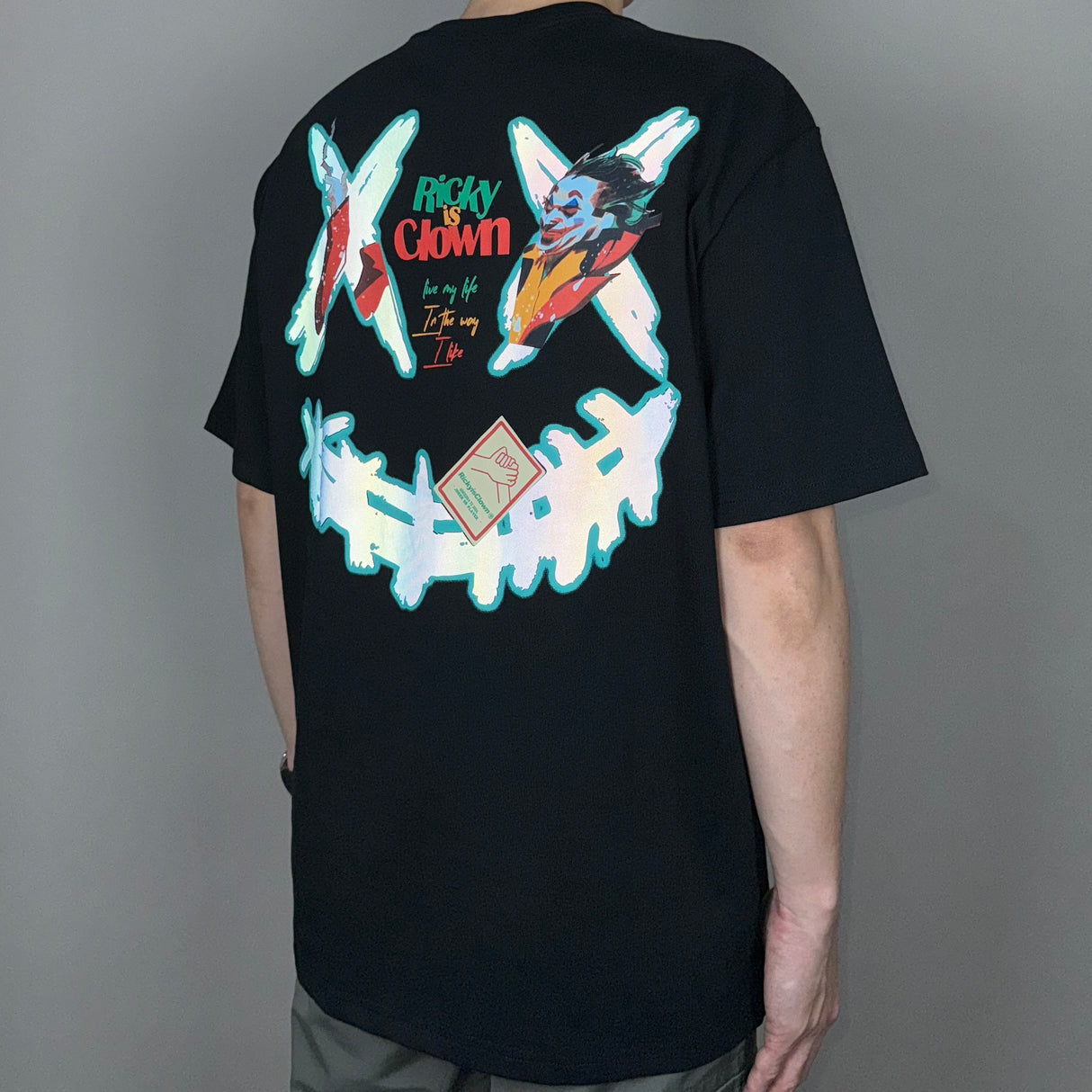 Black Rickyisclown Joker Laser Reflective Smiley T-shirt featuring a reflective smiley face design.