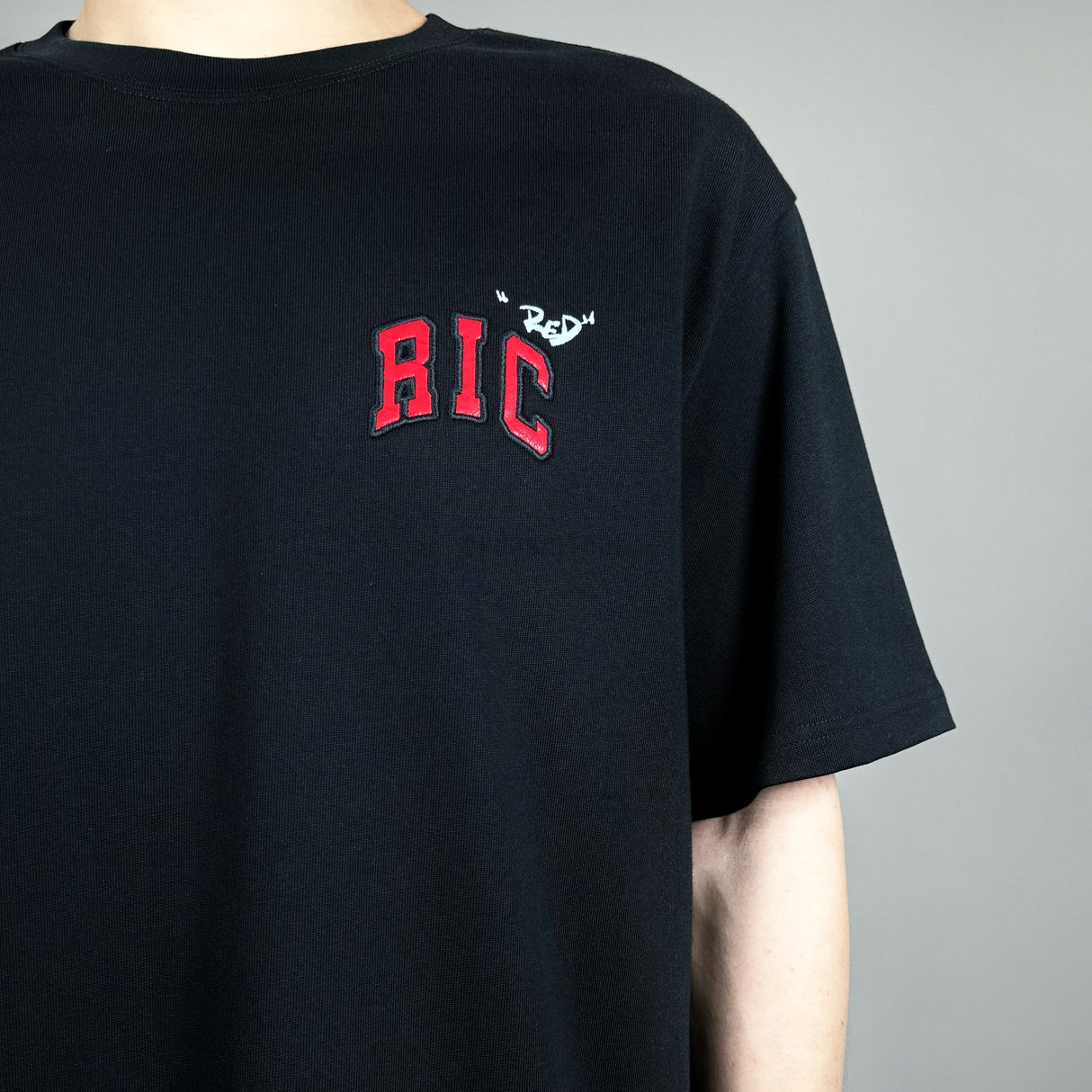 Black Rickyisclown Snake Embossed Chest Tee showcasing a textured snake design on the front, casual men's apparel.