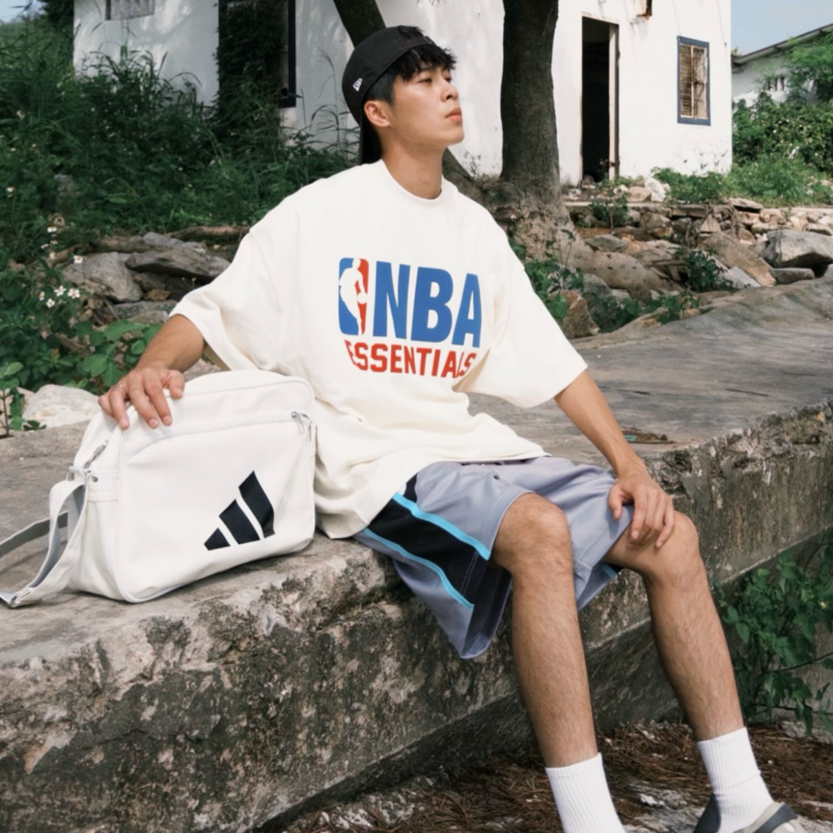 Cream Fear of God Essentials NBA 90s Heavyweight Tee, casual apparel with bold graphic design featuring NBA logo on front.