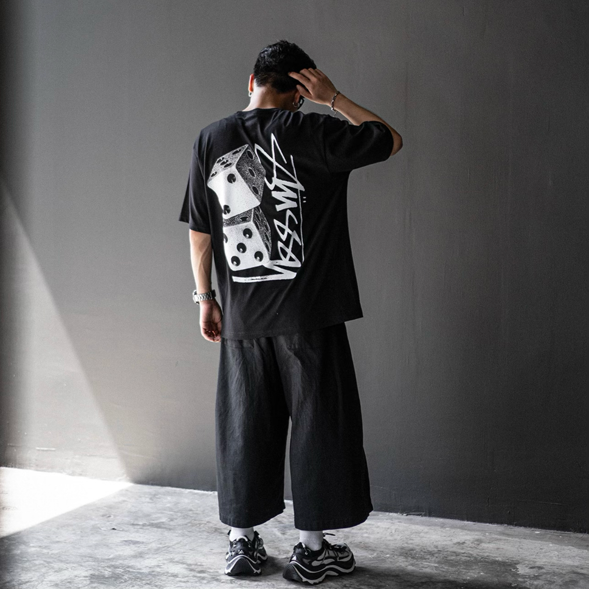 Black Stussy Tall Dice Tee shirt featuring a graphic design with dice print, casual streetwear apparel for men.