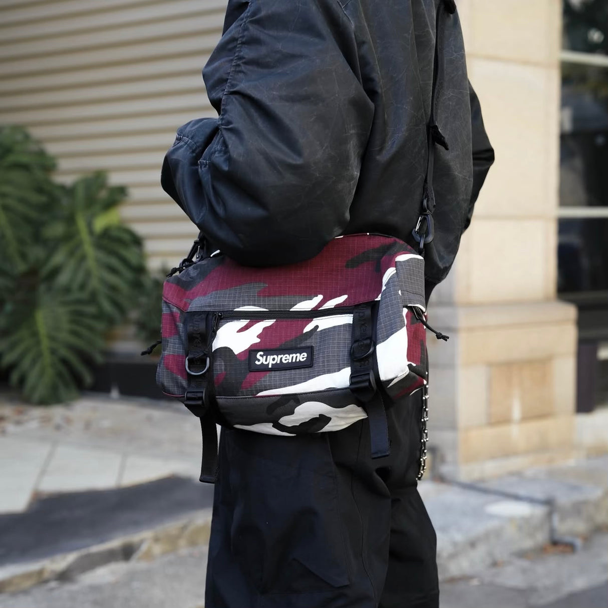 Supreme Box Logo Utility Bag in red camo with adjustable strap and zippered compartments, designed for versatile carrying.