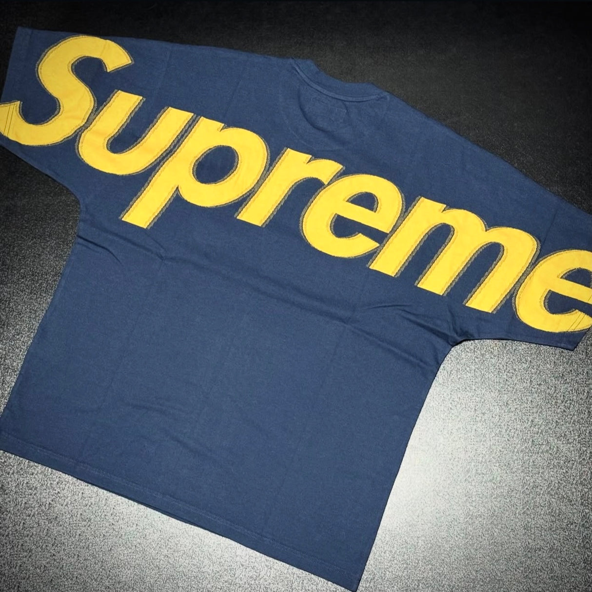 Navy Supreme Intarsia Logo Tee with bold logo design on the front, casual apparel made from soft fabric.