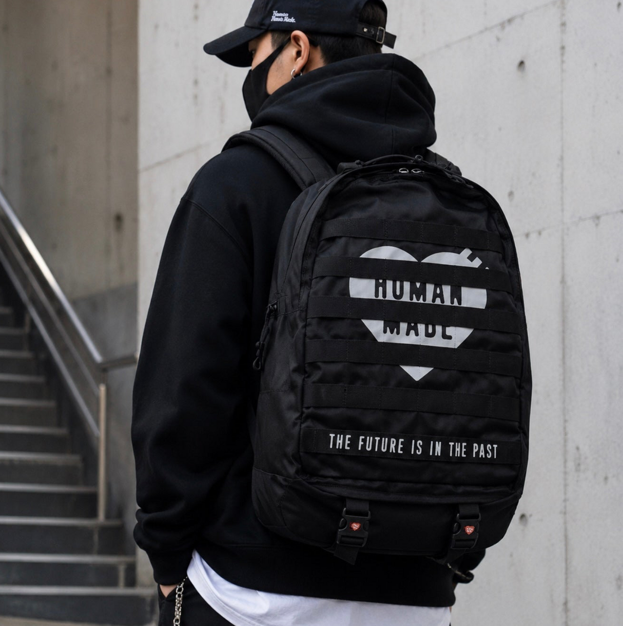 Human Made black military backpack with multiple compartments and adjustable straps, showcasing durable design and urban style.