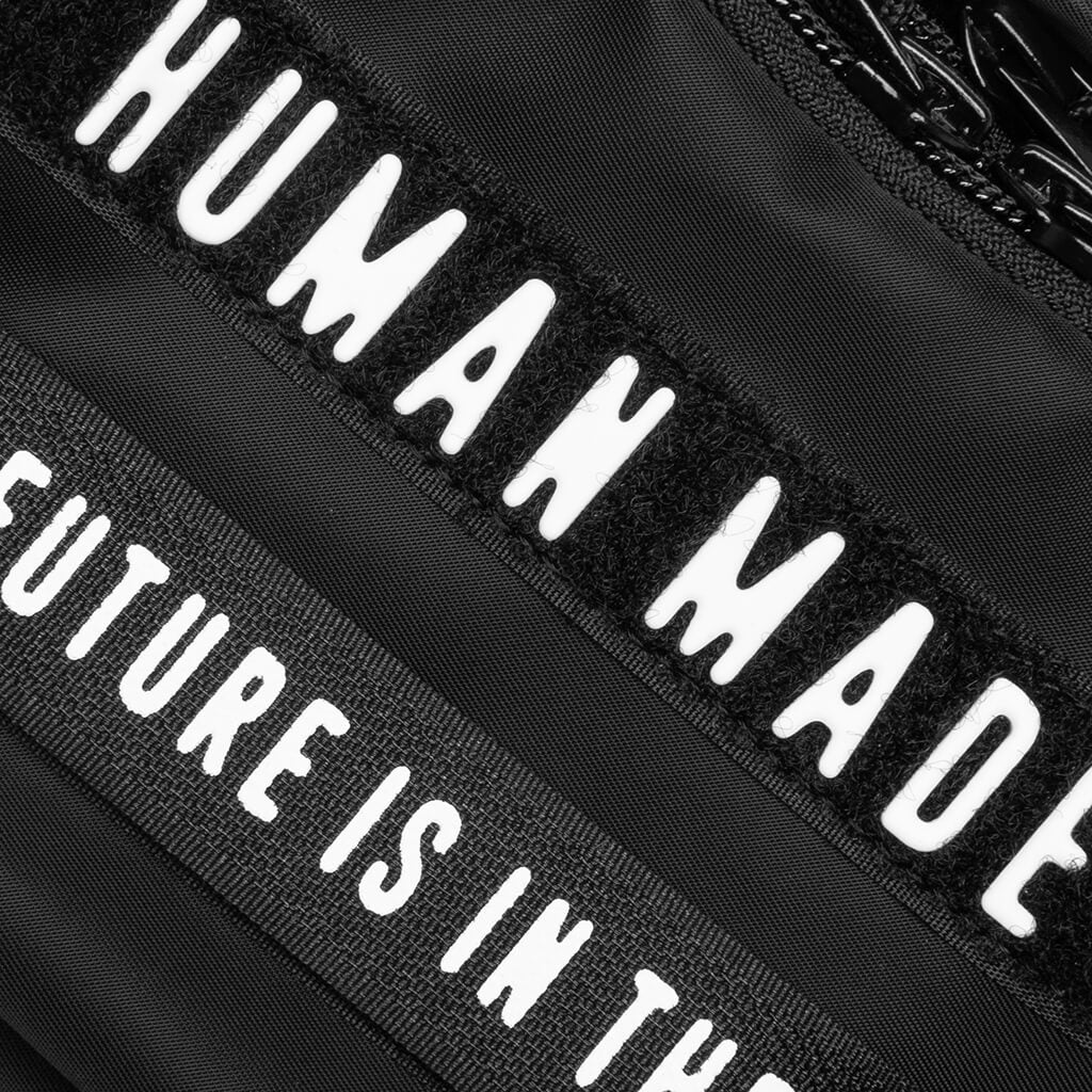 Black Human Made Military Mini Sling Bag with adjustable strap and compact pouch design.