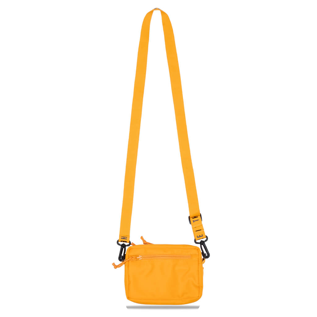 Yellow Human Made military mini sling bag with adjustable strap and compact pouch design, suitable for casual and outdoor use.