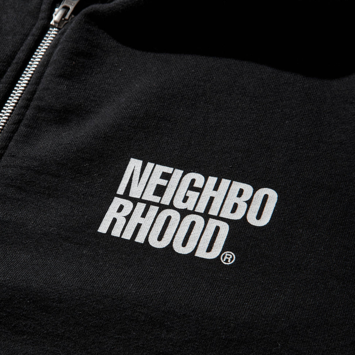 Black NEIGHBORHOOD classic zip hoodie with front pockets and adjustable drawstrings, displayed on a hanger.