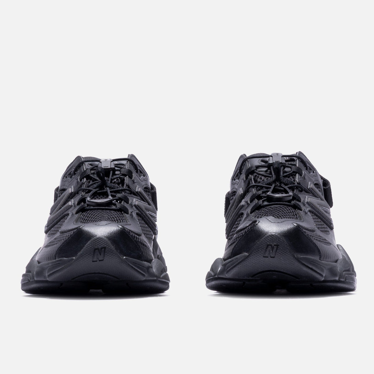 Black New Balance 9060 Mule sneakers featuring sleek design and cushioned soles, showcasing the stylish triple black colorway.