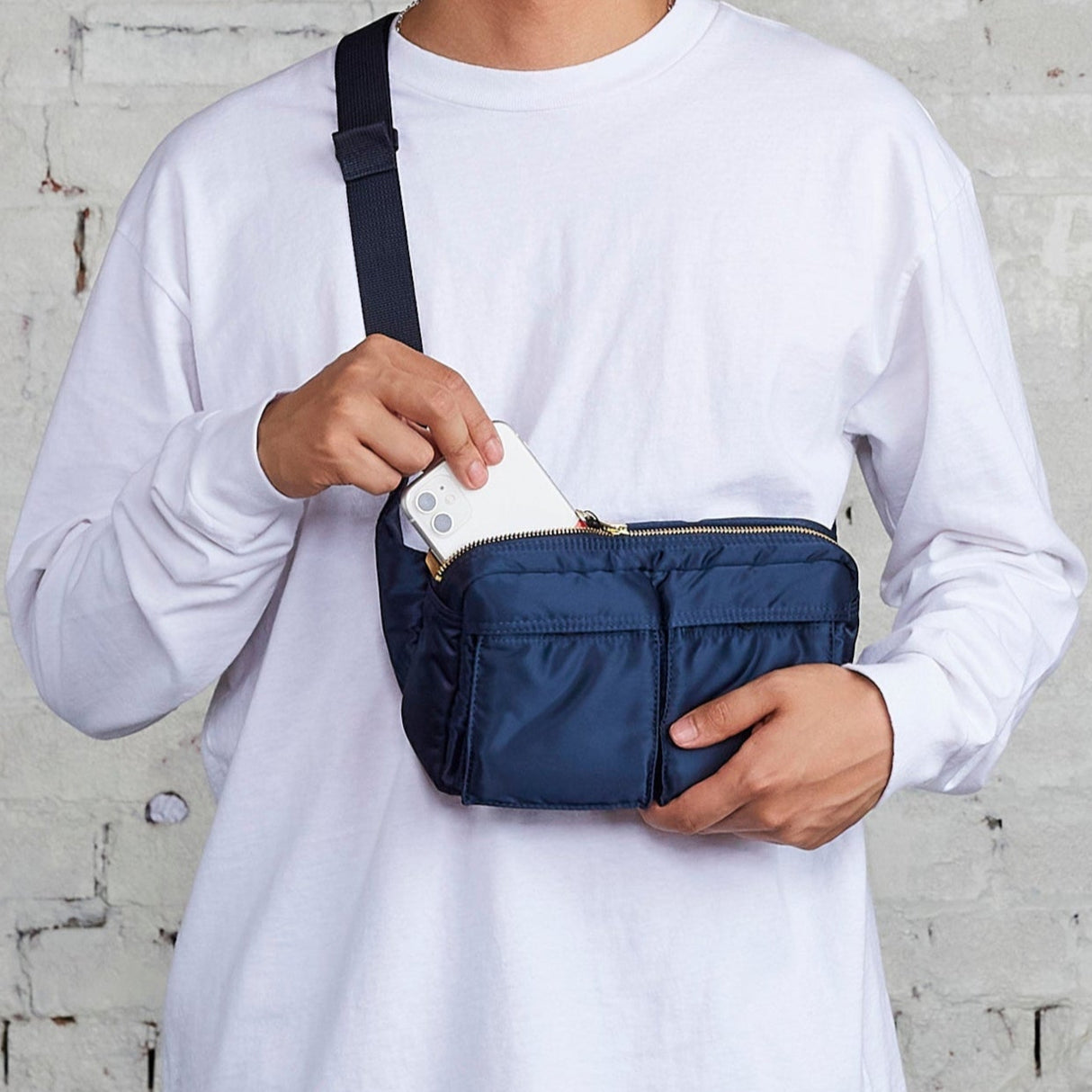 Porter Yoshida Japan Tanker waist bag in iron blue with adjustable strap and multiple compartments, made of durable fabric.