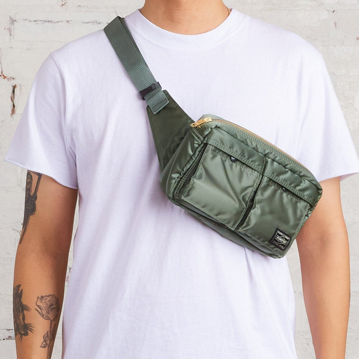 Porter Japan Tanker waist bag in sage green with leather accents, compact design, and adjustable strap for versatile carrying.