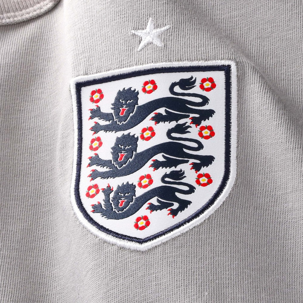 England Nike x Palace Pewter Grey T-shirt featuring Nike branding and England graphic, styled casually with a relaxed fit.