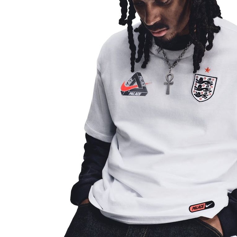 White Nike Palace x England T-shirt with England logo and Nike branding, displayed flat on a neutral background.