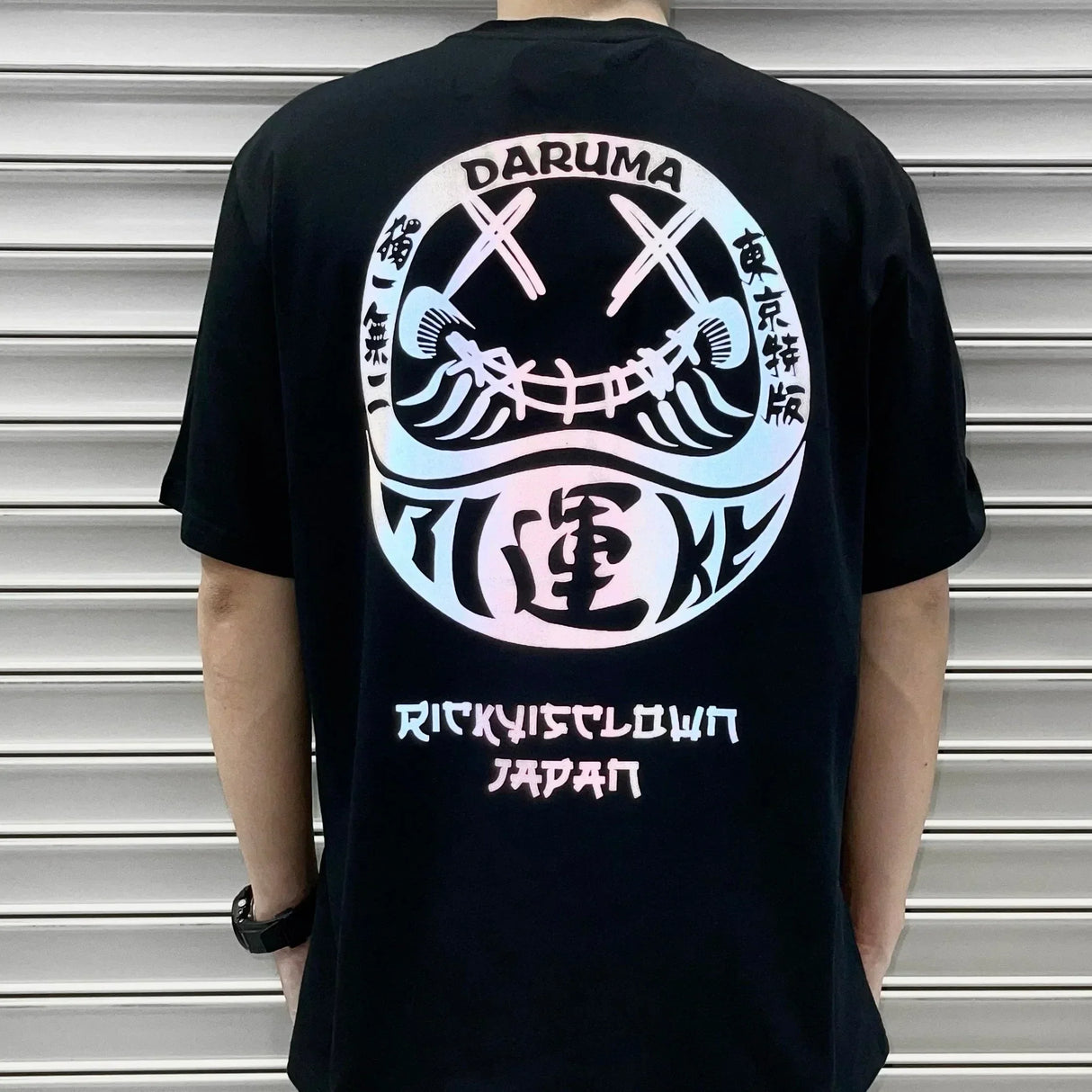 Black Rickyisclown Japan Lucky Daruma laser-reflective T-shirt, featuring bold graphic design, from the RICKYISCLOWN apparel collection.