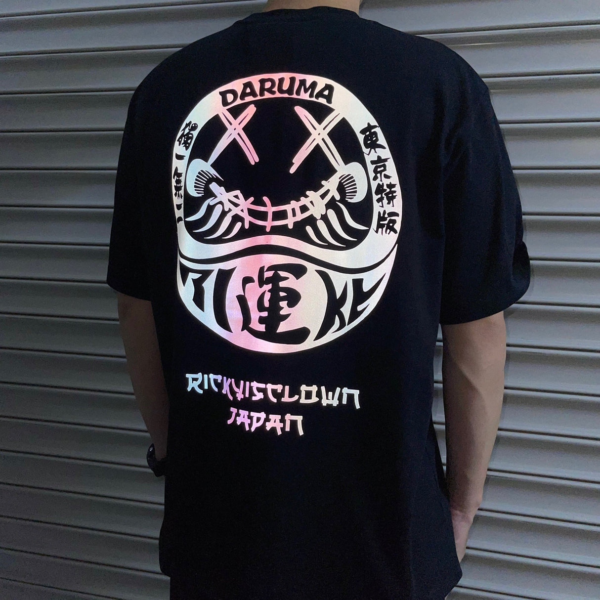 RICKYISCLOWN Japan Lucky Daruma laser-reflective black T-shirt with bold graphic design, casual apparel for everyday wear.
