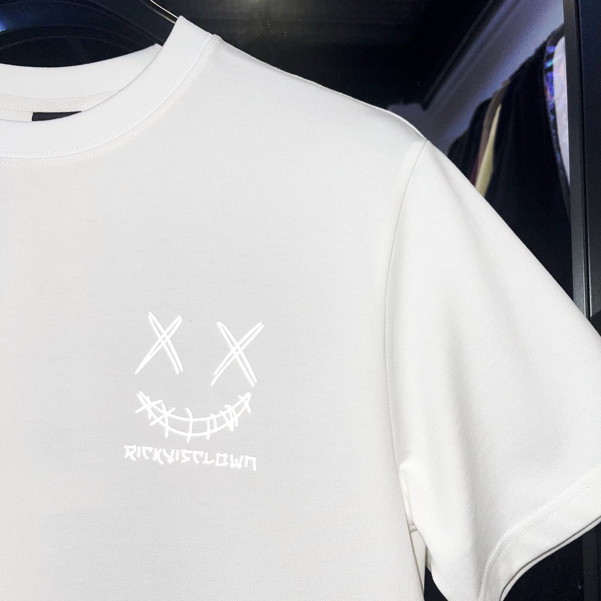 White Rickyisclown Japan Lucky Daruma laser-reflective T-shirt with bold graphic design, casual fit, and brand logo for stylish wear.