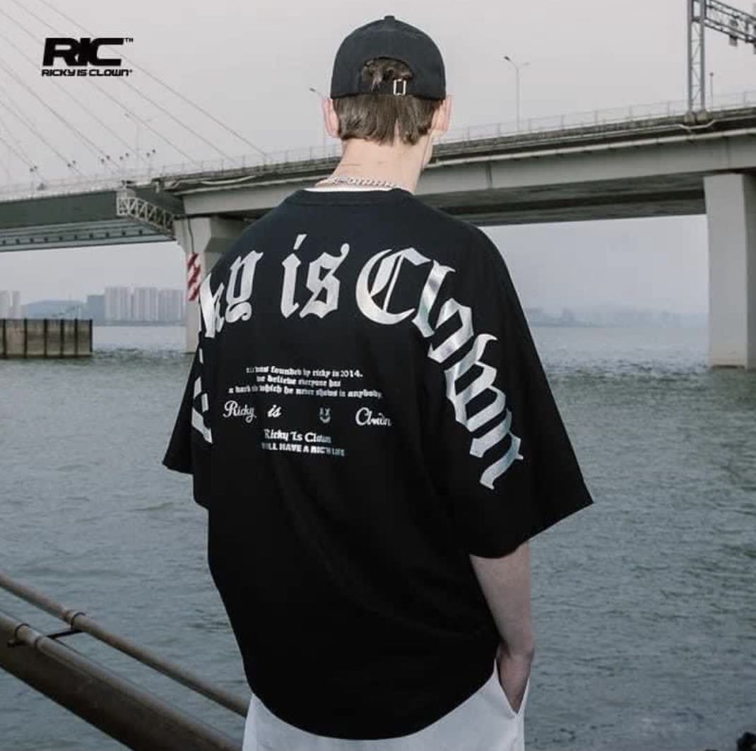 Black holographic gothic drop shoulder T-shirt by RICKYISCLOWN featuring a loose fit and eye-catching shiny fabric details.