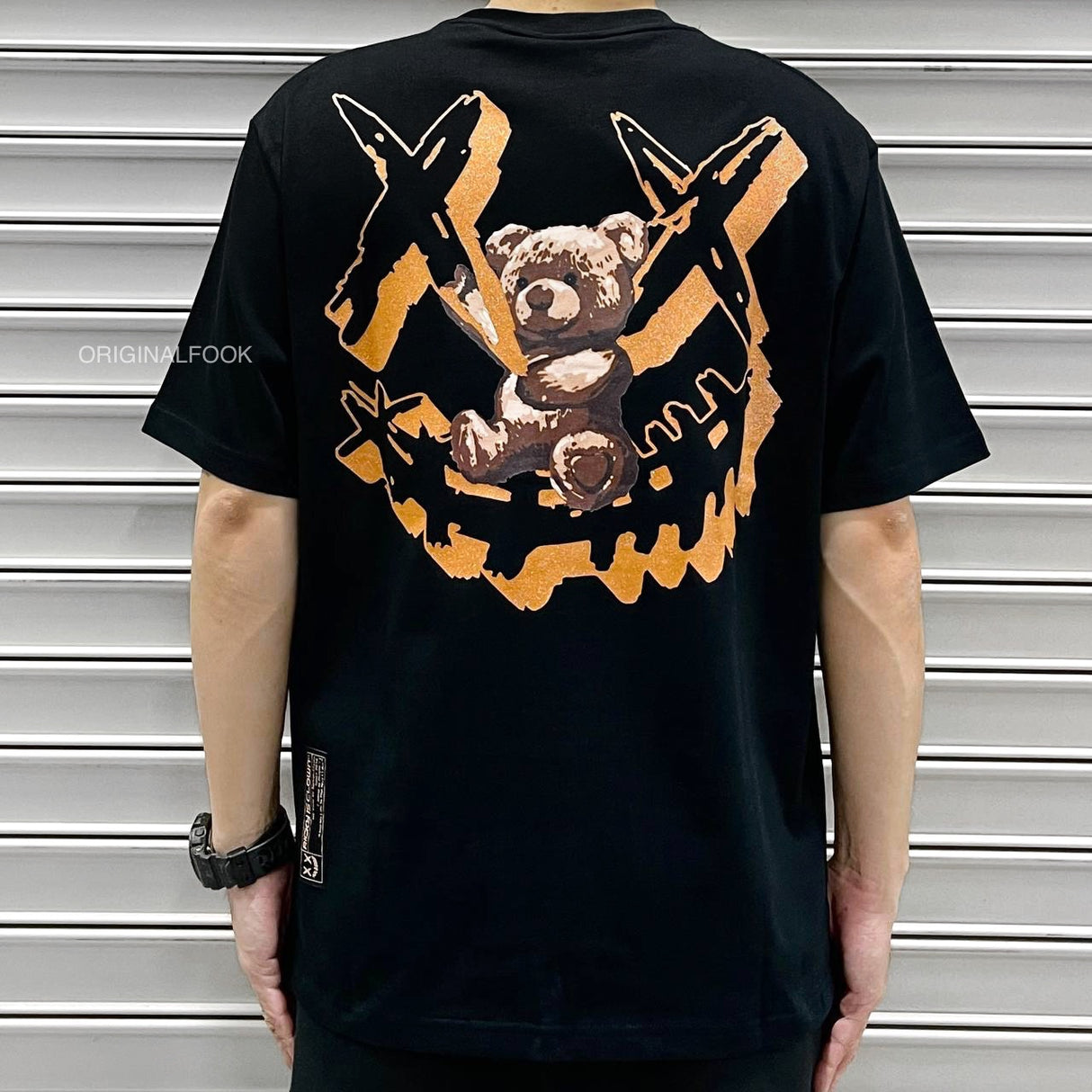 Black Rickyisclown hanging bear smiley t-shirt with graphic design, casual apparel from Rickyisclown, displayed on a hanger.