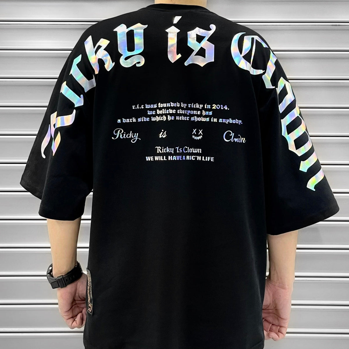 Rickyisclown black holographic gothic drop shoulder tee, casual apparel with reflective design and relaxed fit.