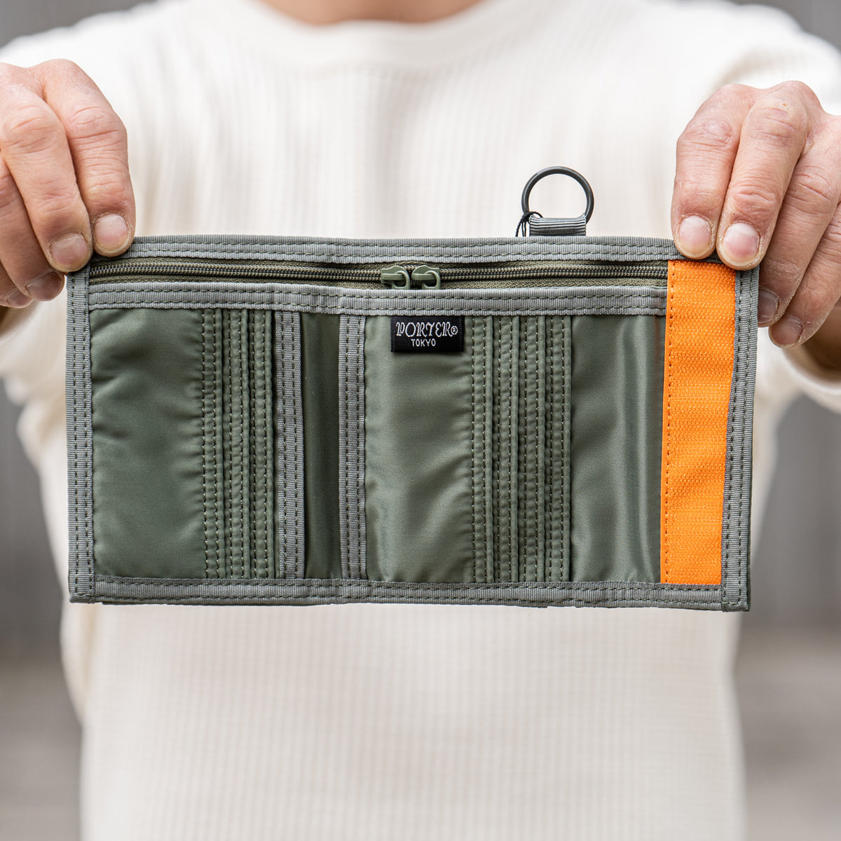 Porter Yoshida Japan Tanker Two-Fold Wallet in sage green, showing the compact bi-fold design and durable fabric material.