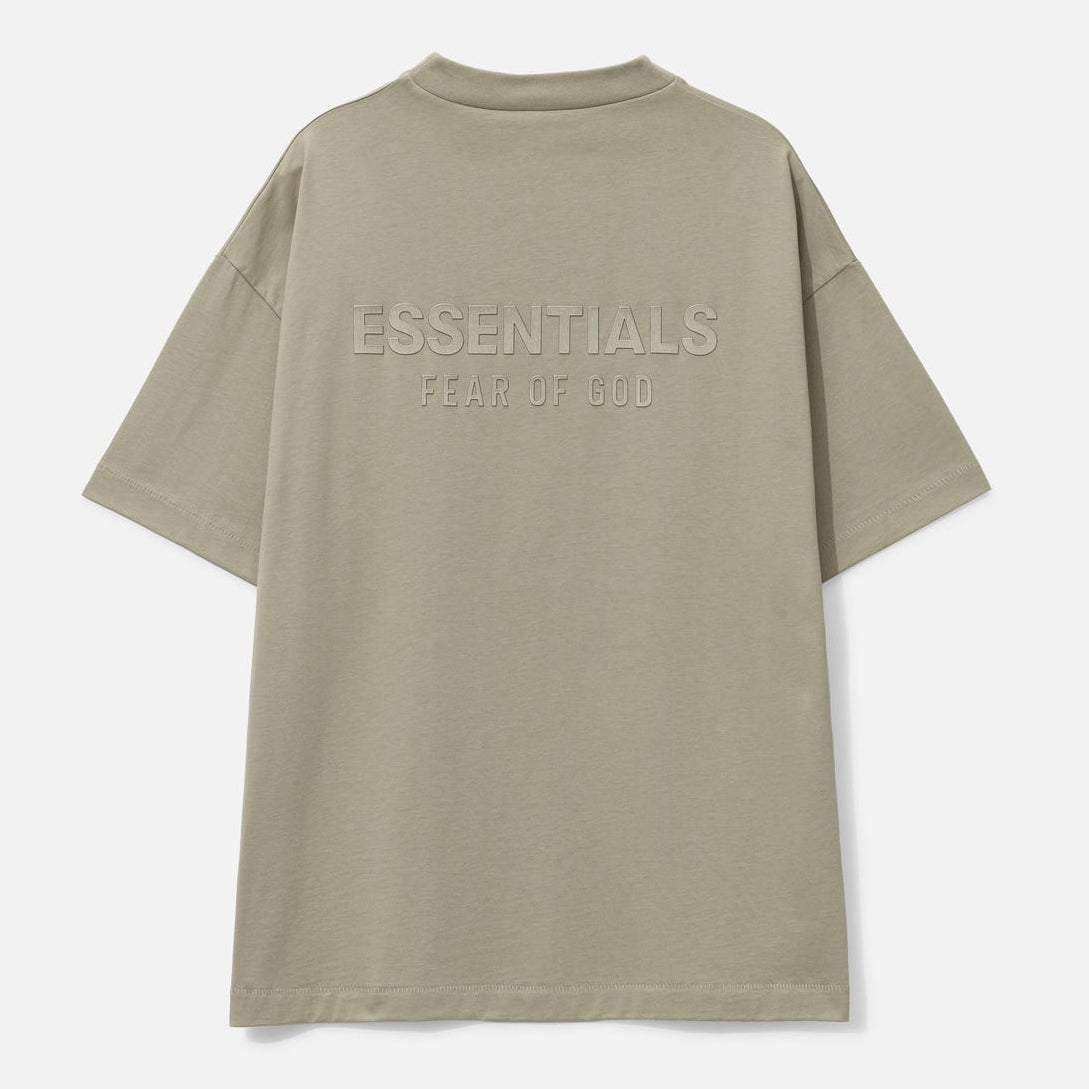 Fear of God Essentials metallic logo classic fit tee in Abbey Stone, showing a casual short-sleeve t-shirt with logo details.