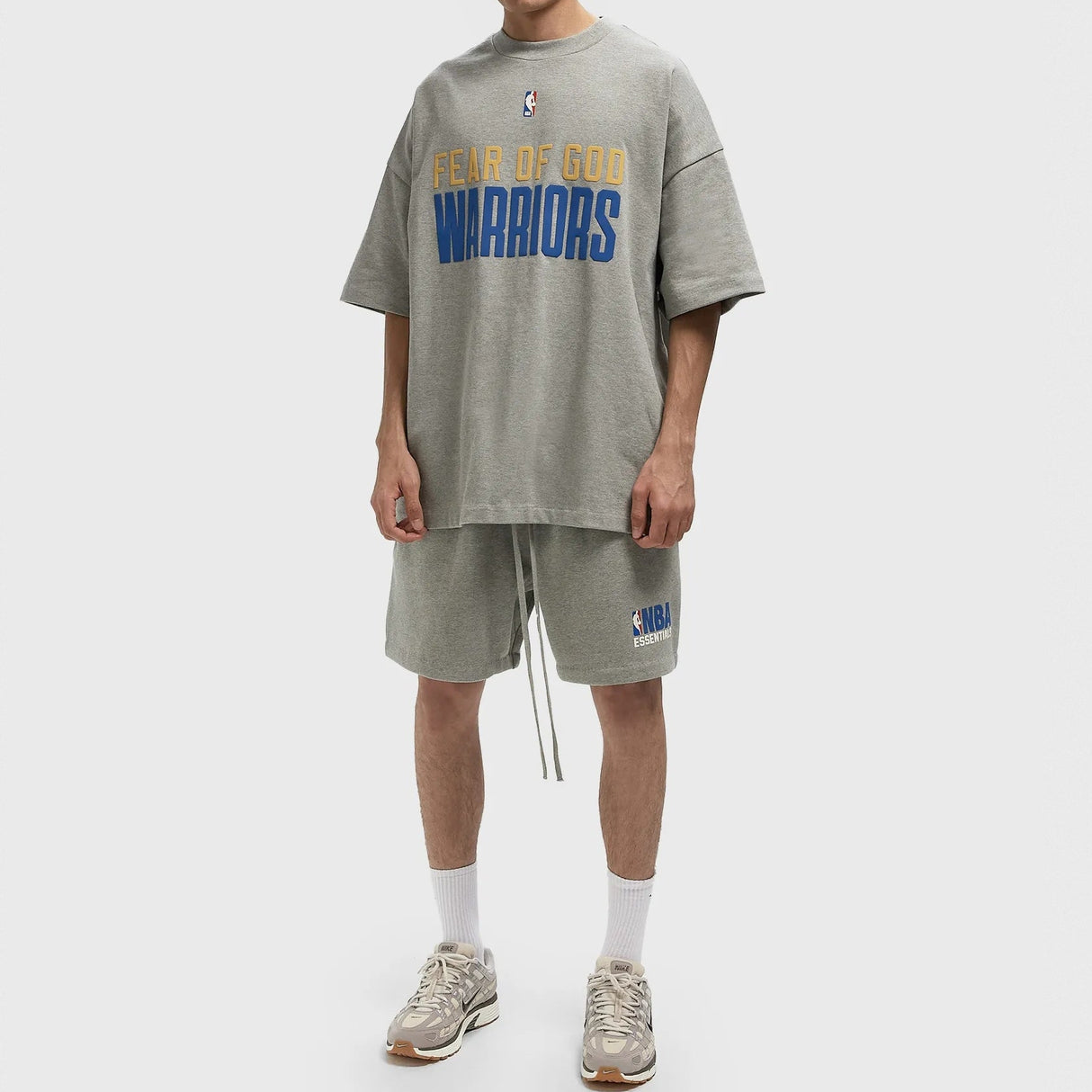 Fear of God Essentials NBA logo sweat shorts in concrete heather, featuring a relaxed fit and sports-inspired design.