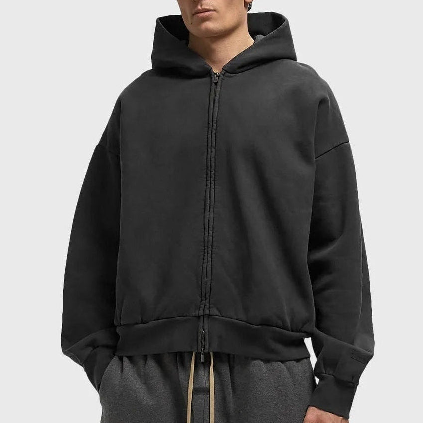 Fear Of God Essentials logo zip-up hoodie in vintage black, featuring a classic design and front logo on soft apparel fabric.