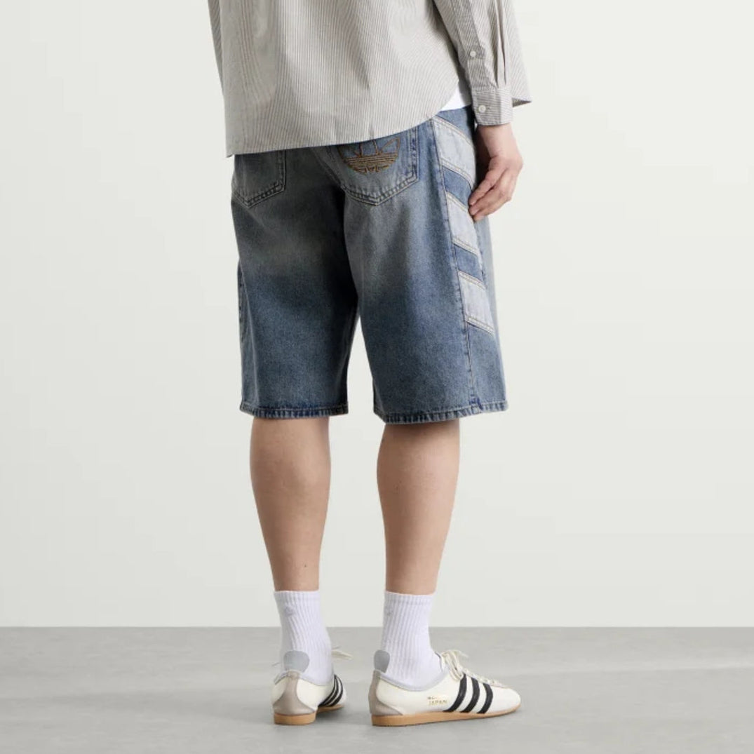 Adidas indigo denim shorts for women, with a classic fit and casual style, displayed on a hanger against a white background.