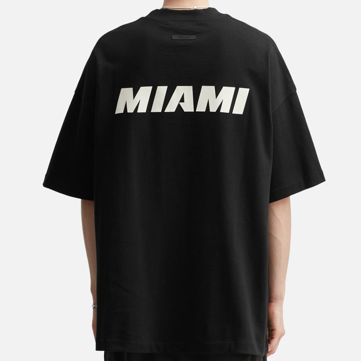 Fear of God Essentials X HEAT NBA 90s Heavyweight Tee in black, displayed on a plain background.