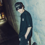 Black Mastermind Japan X New Era trucker cap with embroidered logo, mesh back, and adjustable strap.