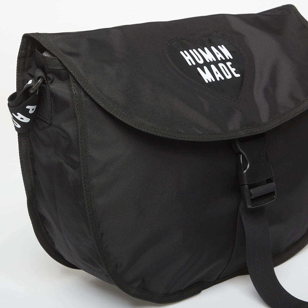 Black Human Made shoulder bag with adjustable strap and minimalist design, made of durable material.