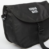 Black Human Made shoulder bag with adjustable strap and minimalist design, made of durable material.