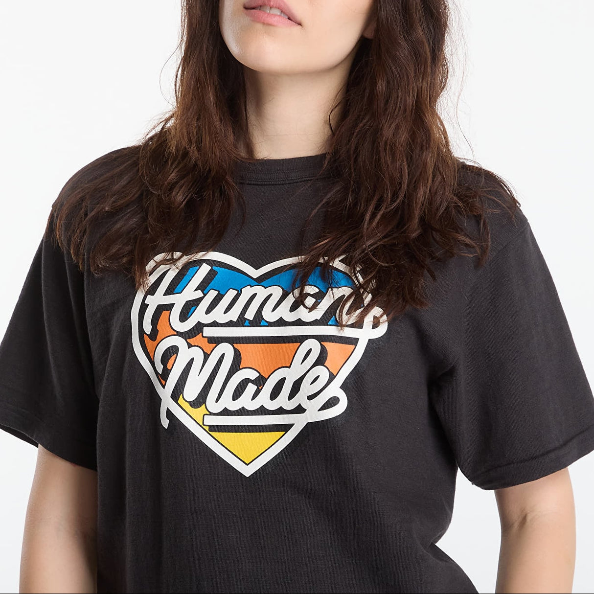 Human Made black T-shirt featuring a tri-color heart logo, casual apparel with a bold graphic design.