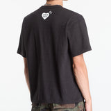 Human Made Tri-Color Heart Logo Tee in black, casual t-shirt with colorful heart graphic on the front, made of soft fabric.